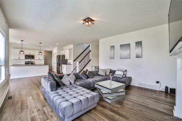 living room with plenty of natural light, sink, and hardwood / wood-style floors