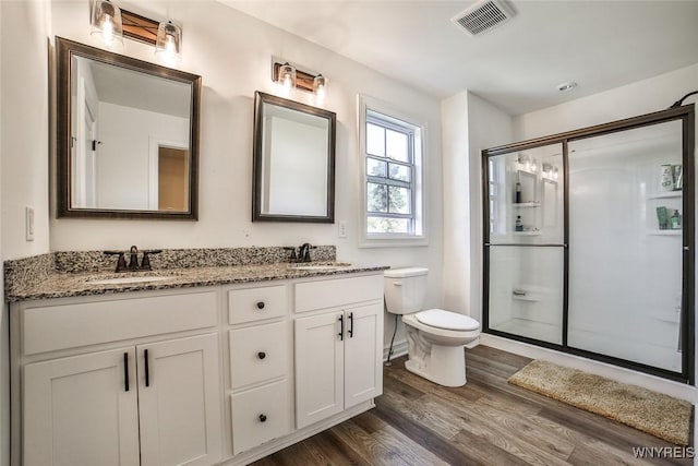 bathroom with vanity, hardwood / wood-style floors, an enclosed shower, and toilet