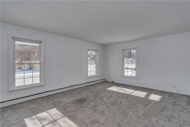 carpeted empty room with a baseboard heating unit