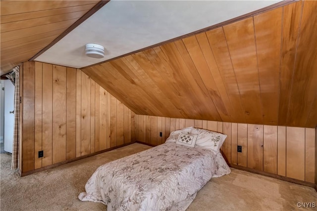 carpeted bedroom featuring vaulted ceiling and wood walls