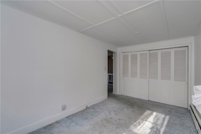 unfurnished bedroom with light carpet, baseboard heating, and a closet