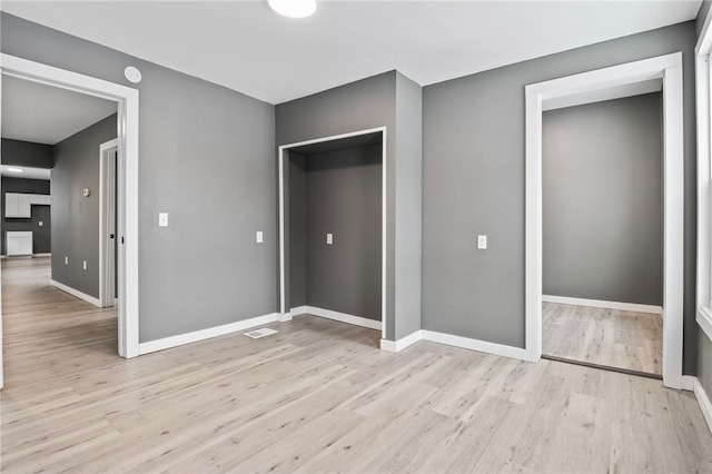 unfurnished bedroom featuring light hardwood / wood-style floors and a closet