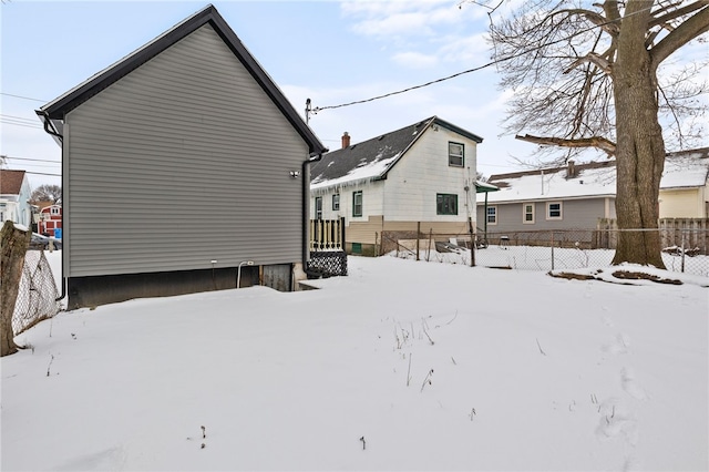 view of snow covered back of property