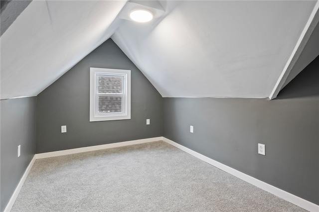 bonus room with lofted ceiling and carpet flooring