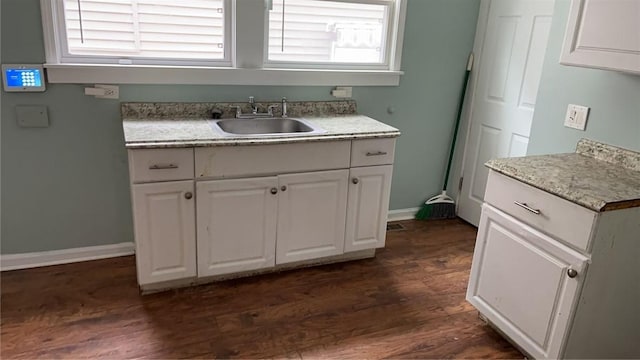 kitchen with dark hardwood / wood-style flooring, sink, a healthy amount of sunlight, and white cabinets