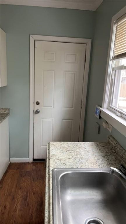 interior space featuring dark hardwood / wood-style floors, sink, and white cabinets