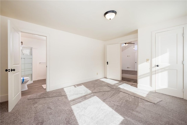 unfurnished bedroom featuring carpet, ensuite bath, and a closet