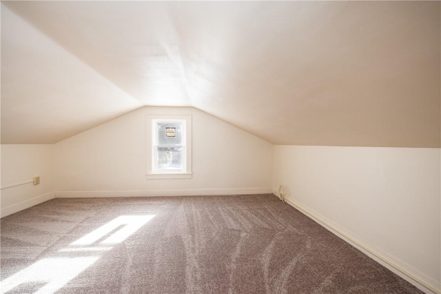 bonus room with lofted ceiling and carpet flooring