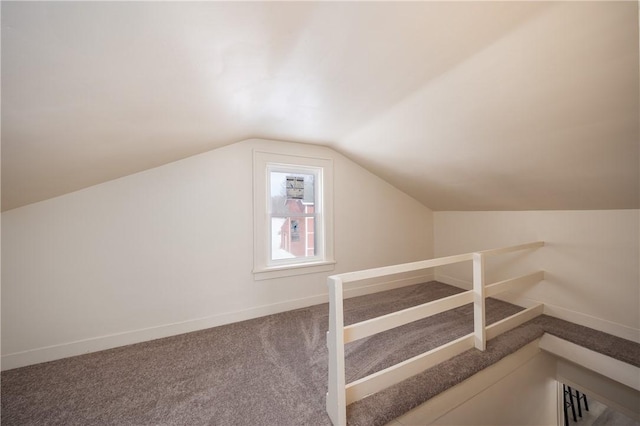 additional living space featuring vaulted ceiling and carpet