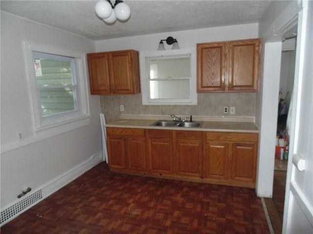 kitchen featuring sink, decorative backsplash, and dark parquet floors