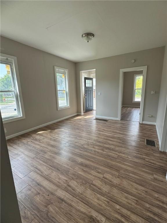 empty room featuring plenty of natural light and hardwood / wood-style floors