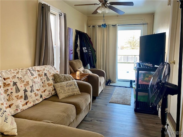 living room with dark wood-type flooring and ceiling fan