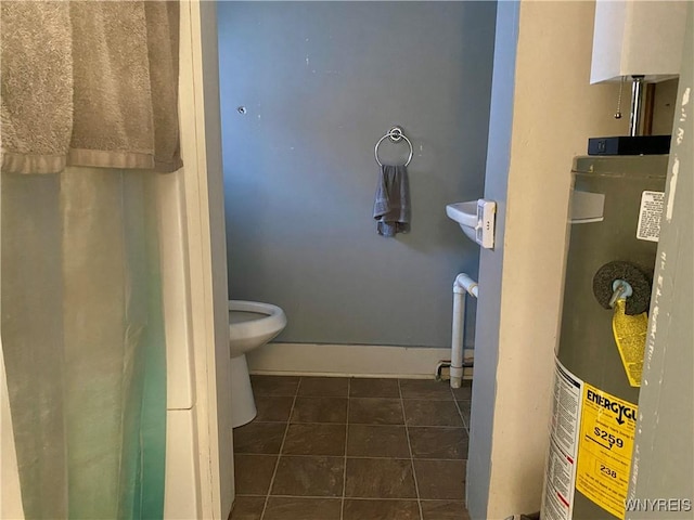 bathroom with water heater, tile patterned flooring, and toilet