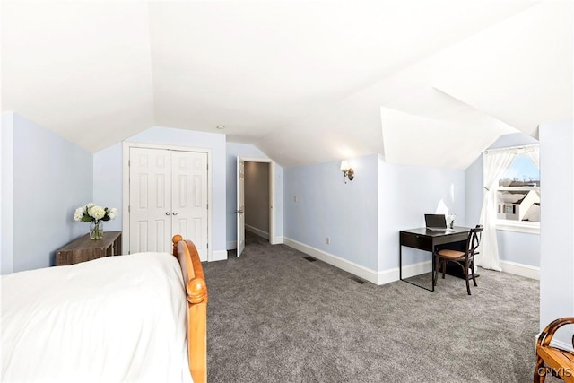 carpeted bedroom with lofted ceiling and a closet