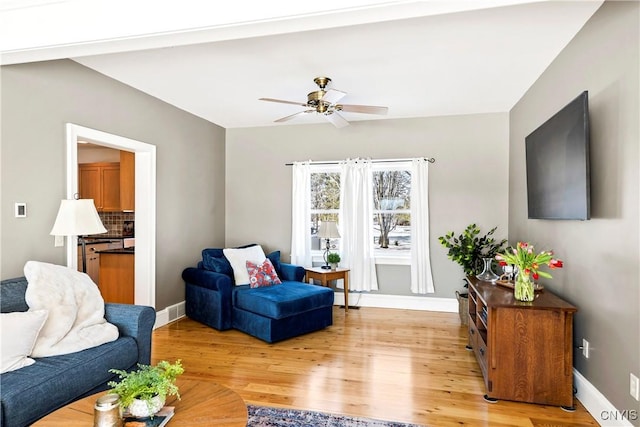 living room with ceiling fan and light wood-type flooring