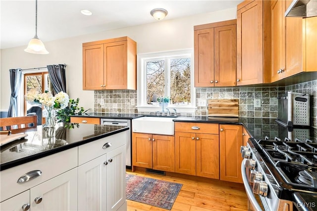 kitchen featuring stainless steel appliances, a healthy amount of sunlight, sink, and decorative light fixtures