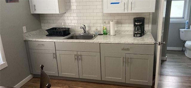 kitchen featuring tasteful backsplash, sink, white cabinets, and dark hardwood / wood-style floors