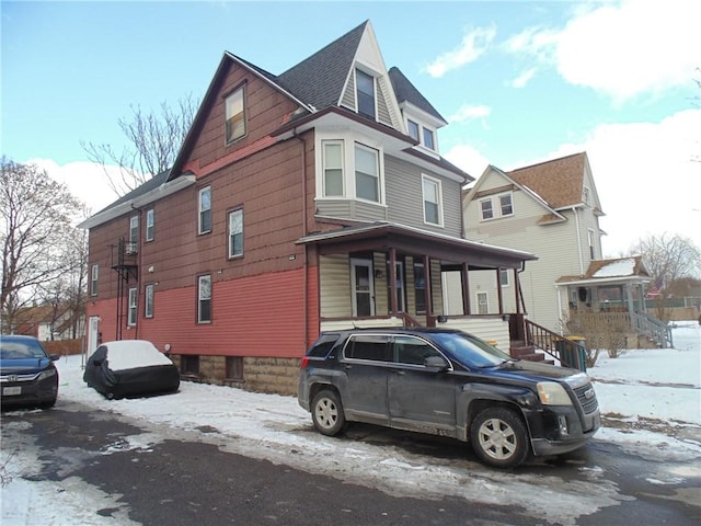 view of snowy exterior featuring covered porch