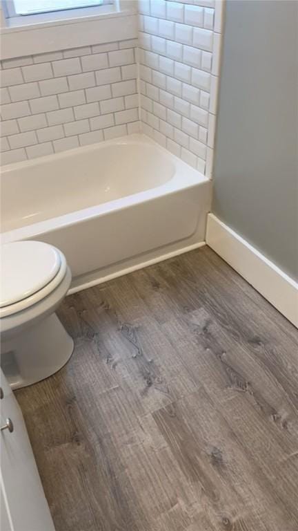 bathroom featuring shower / bath combination, hardwood / wood-style floors, and toilet