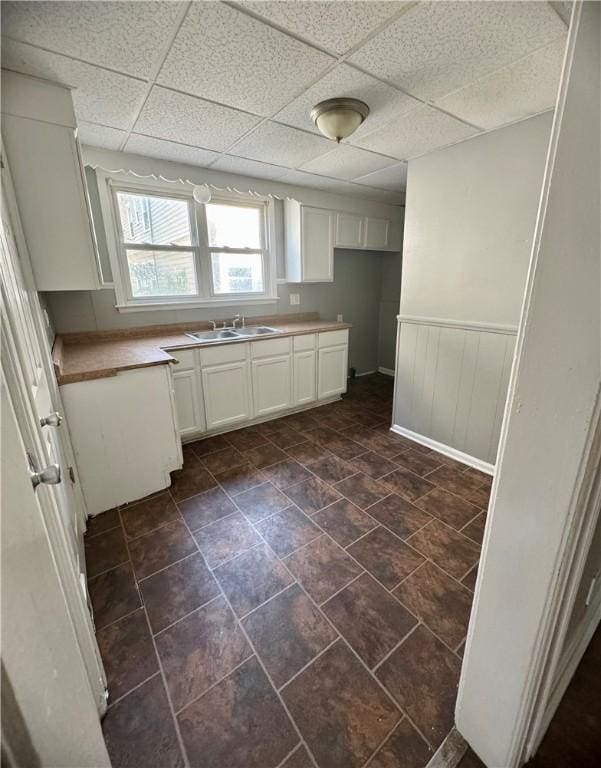 kitchen featuring white cabinetry, sink, and a paneled ceiling