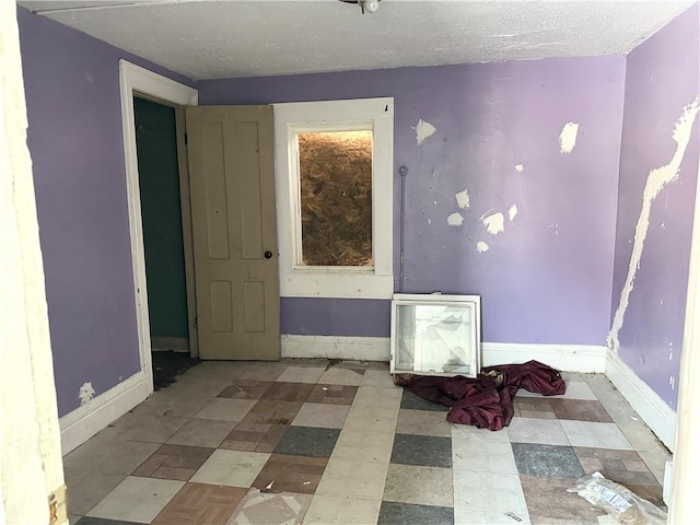 unfurnished room with a textured ceiling