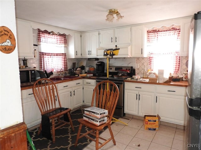 kitchen with white cabinets, appliances with stainless steel finishes, plenty of natural light, and backsplash