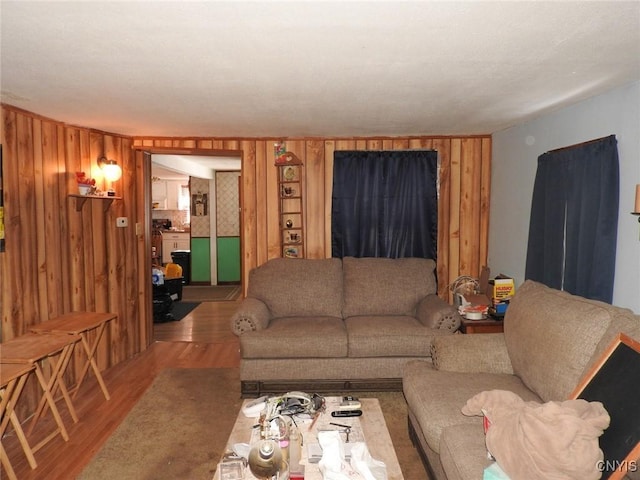 living room with light wood-type flooring and wood walls