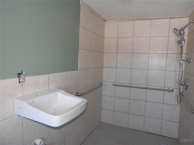 bathroom with tiled shower and tile patterned flooring