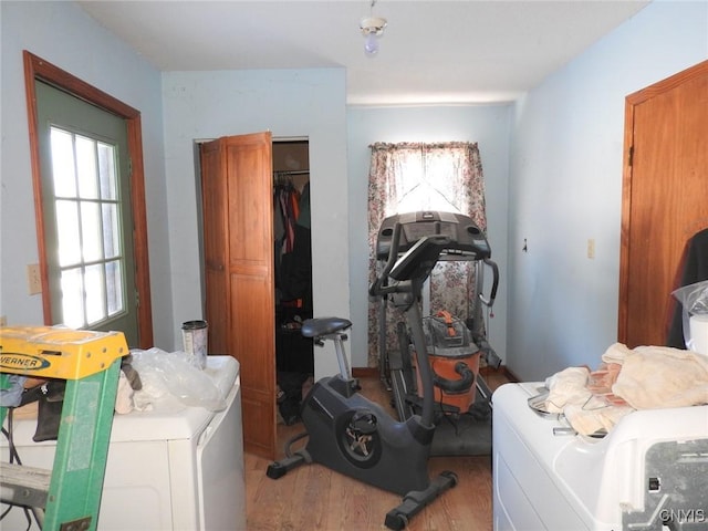 workout room with washer / clothes dryer and light hardwood / wood-style flooring