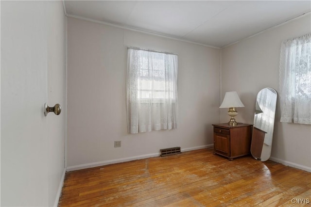 empty room featuring light hardwood / wood-style flooring and ornamental molding