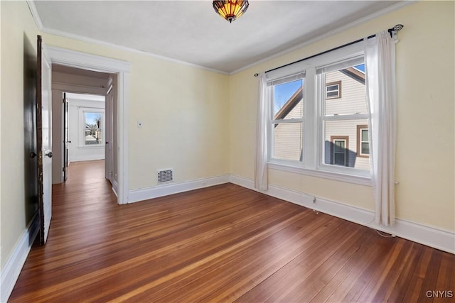 empty room featuring crown molding and dark hardwood / wood-style floors