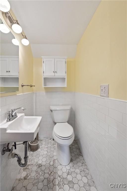 bathroom featuring sink, tile walls, tile patterned floors, and toilet