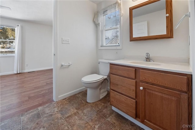 bathroom featuring vanity, plenty of natural light, and toilet