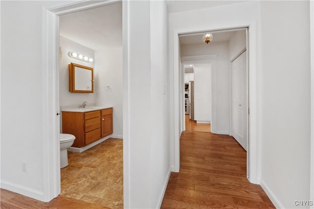 hallway featuring sink and light hardwood / wood-style flooring