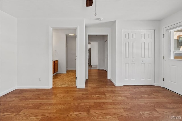 unfurnished bedroom with light hardwood / wood-style flooring, a closet, ceiling fan, and ensuite bathroom