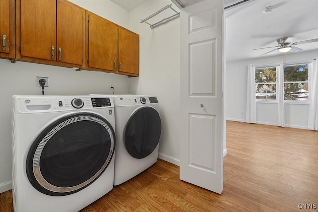 laundry area with ceiling fan, cabinets, washer and dryer, and light wood-type flooring