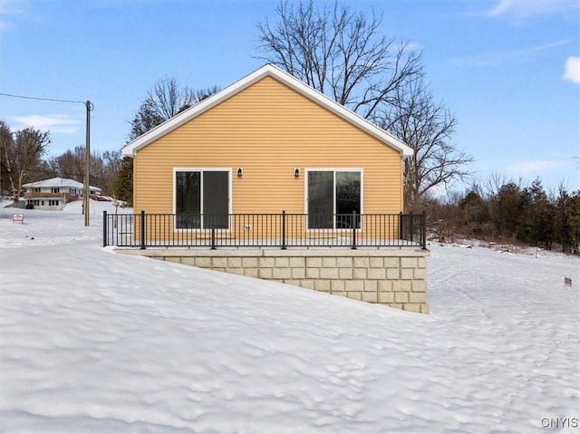 view of snow covered back of property