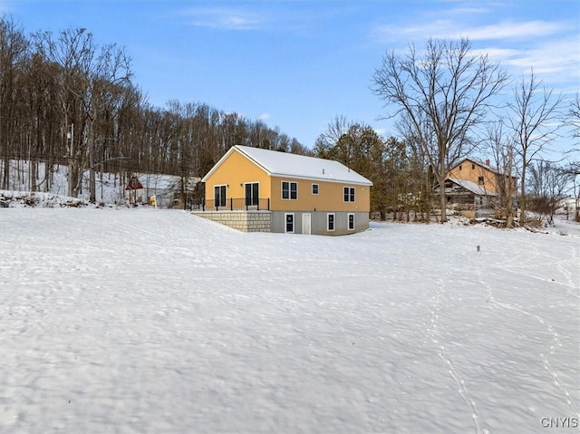 view of snow covered back of property