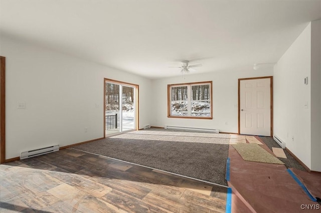 unfurnished living room with a baseboard heating unit, dark wood-type flooring, and ceiling fan