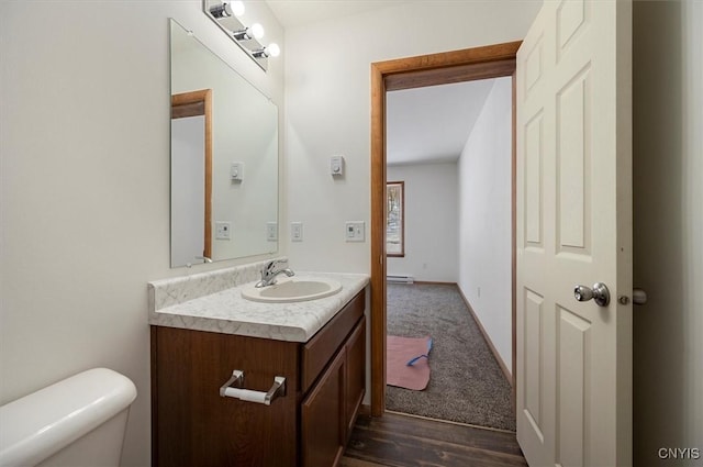 bathroom with baseboard heating, vanity, toilet, and hardwood / wood-style floors