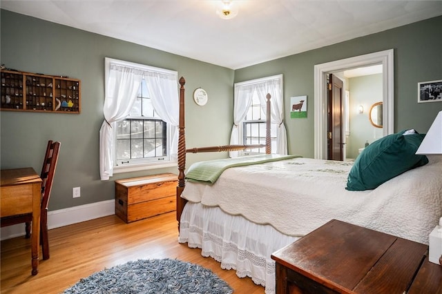 bedroom with hardwood / wood-style flooring and connected bathroom