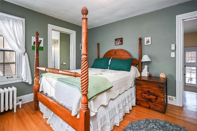 bedroom featuring hardwood / wood-style flooring and radiator