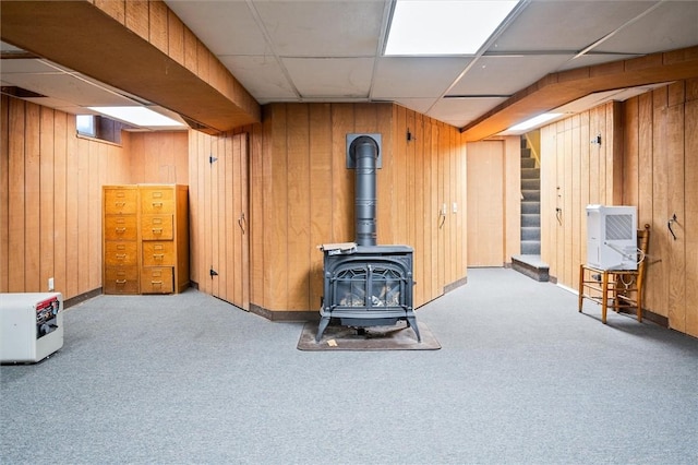 basement with light carpet, heating unit, and wood walls