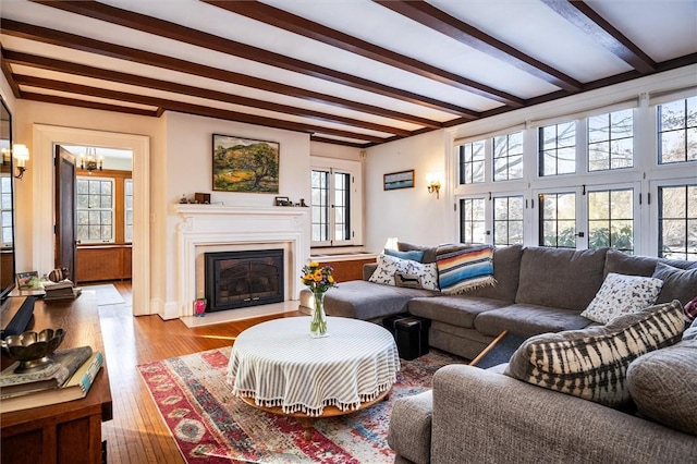 living room with beam ceiling and light hardwood / wood-style floors