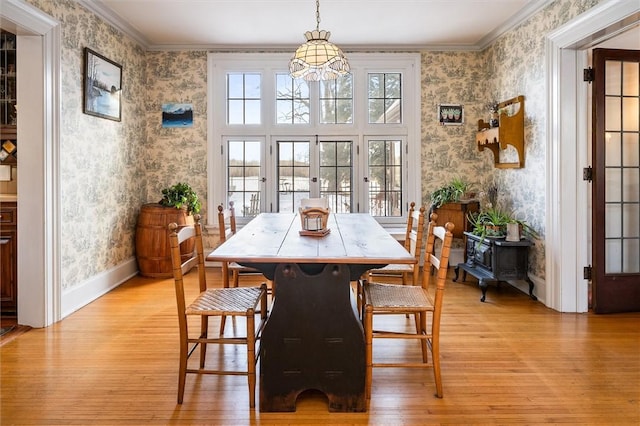 dining area featuring ornamental molding, light hardwood / wood-style flooring, and french doors