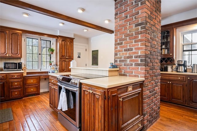 kitchen with tasteful backsplash, light hardwood / wood-style floors, beamed ceiling, and appliances with stainless steel finishes