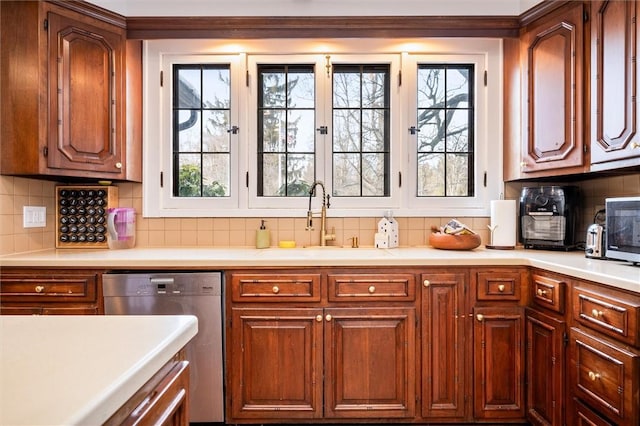 kitchen featuring stainless steel dishwasher, sink, and decorative backsplash