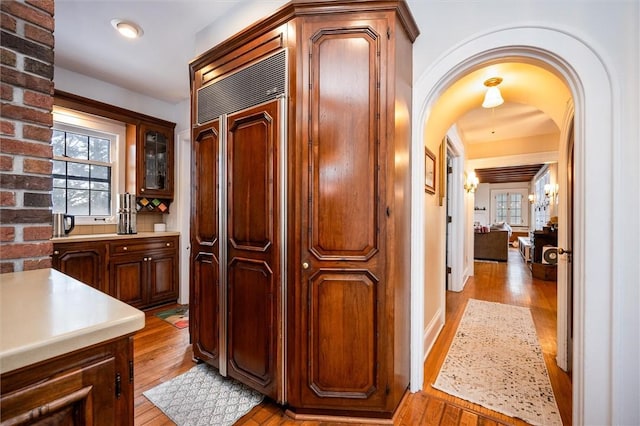 kitchen with backsplash, light hardwood / wood-style flooring, and paneled built in fridge