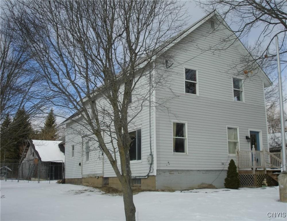 view of snow covered back of property