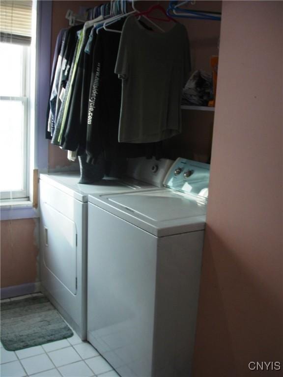 washroom featuring washer and dryer, a healthy amount of sunlight, and light tile patterned flooring